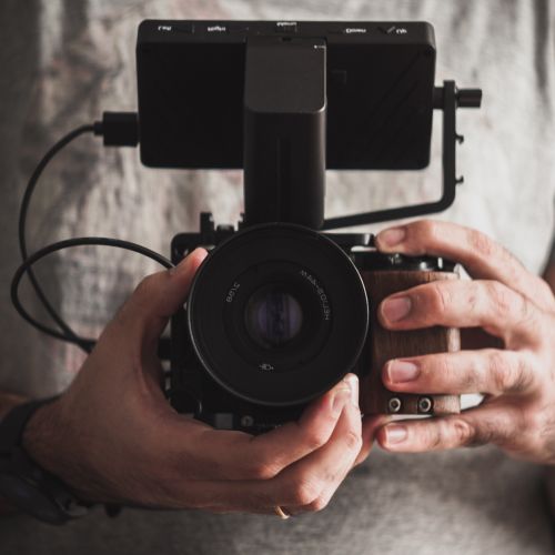 Photographe professionnel tenant une caméra en gros plan – équipement de qualité à Baie-St-Paul